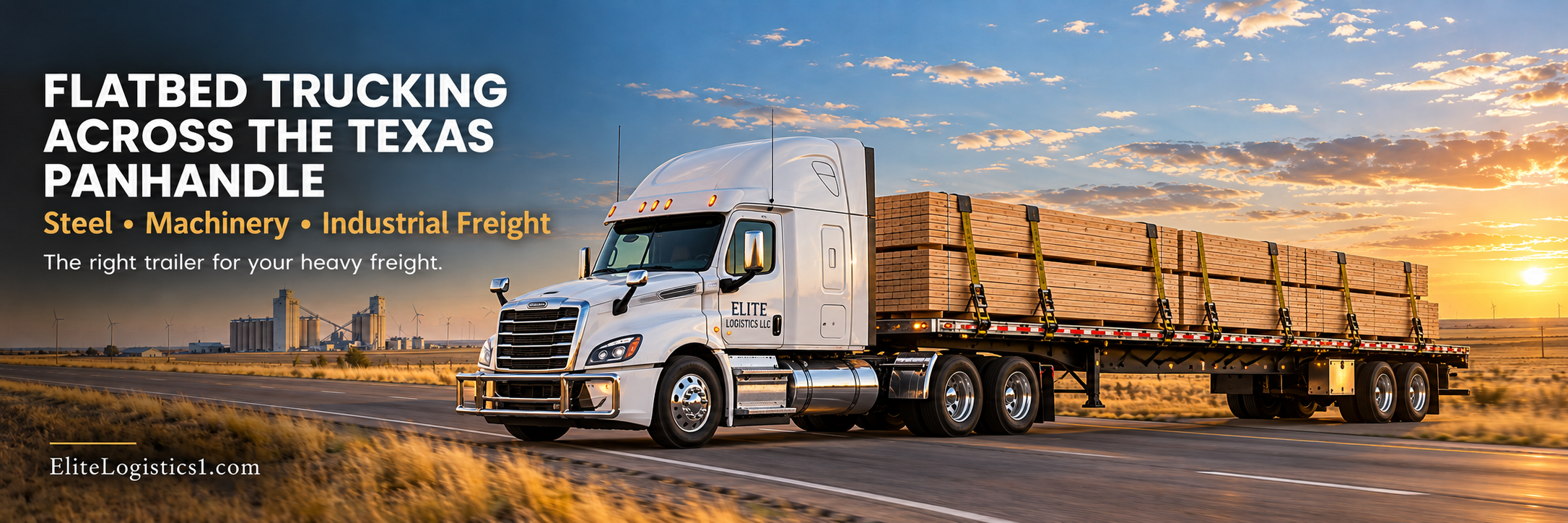 Flatbed trucking across the Texas Panhandle – Elite Logistics LLC white semi hauling strapped lumber on a flatbed trailer past grain elevators at sunset