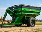 Green grain cart with a folded unloading auger in a harvested field, ready for grain cart hauling and farm equipment transport
